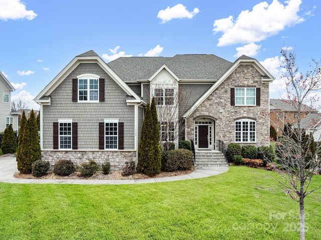 view of front facade featuring stone siding, a front lawn, and a shingled roof