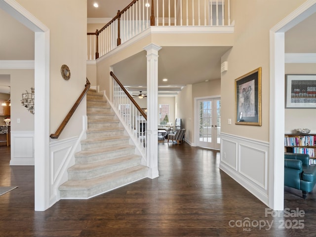 entrance foyer with ornate columns, crown molding, stairs, and wood finished floors