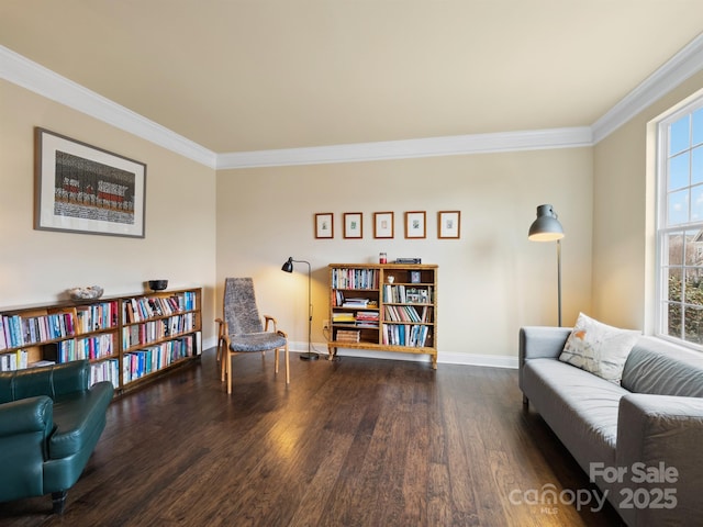 living area with ornamental molding, wood finished floors, and baseboards