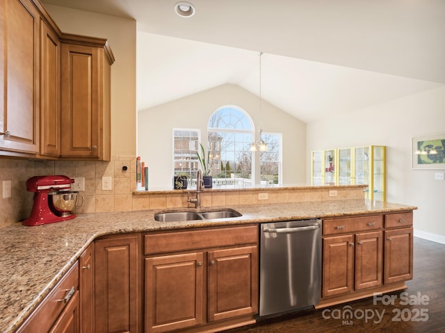 kitchen with a sink, vaulted ceiling, brown cabinets, light stone countertops, and dishwasher