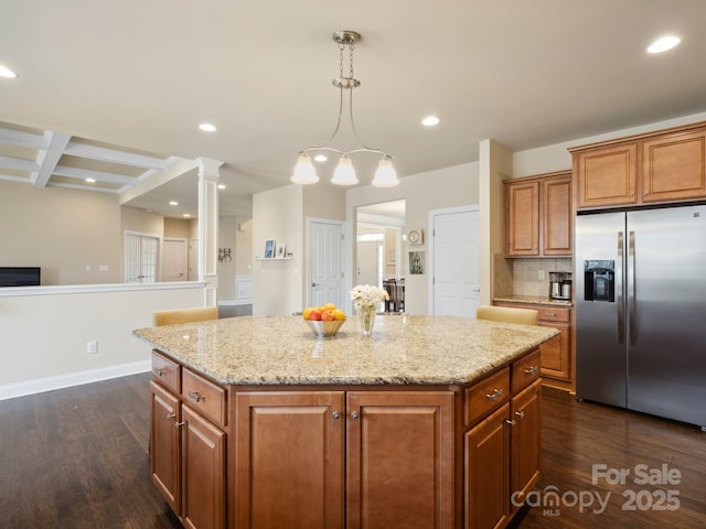 kitchen featuring brown cabinets, stainless steel fridge, dark wood finished floors, and a center island