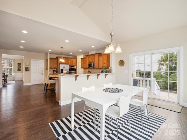 dining space featuring lofted ceiling, dark wood-style flooring, baseboards, and recessed lighting