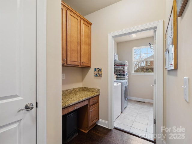 laundry area featuring laundry area, wood finished floors, washing machine and dryer, and baseboards