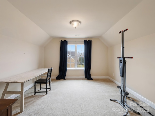 office space featuring lofted ceiling, baseboards, and light colored carpet