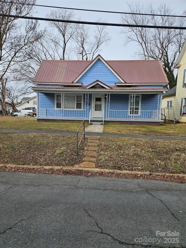 view of front of home with covered porch and a front lawn