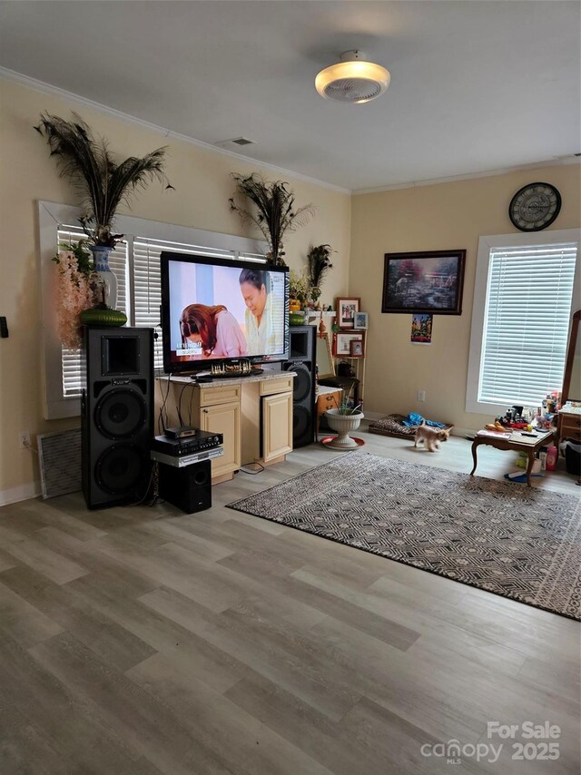 living room featuring ornamental molding and light wood-type flooring