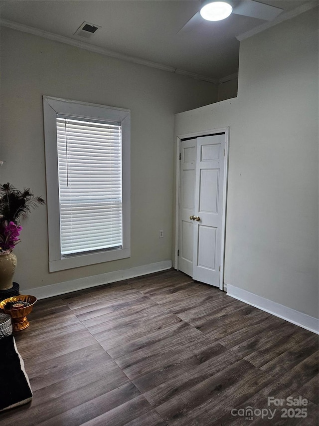 unfurnished bedroom with ceiling fan, ornamental molding, and hardwood / wood-style floors