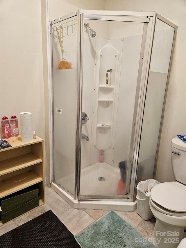 bathroom with toilet and a shower with door