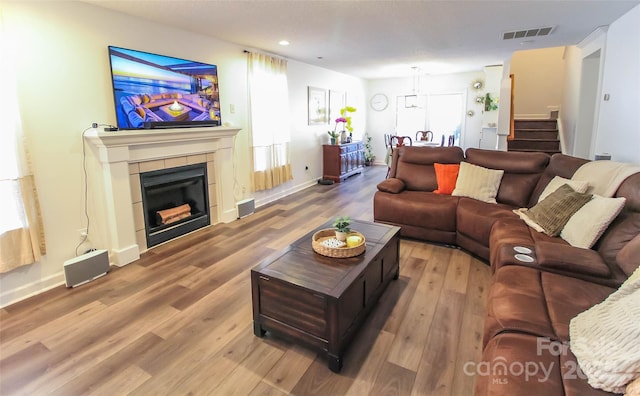 living room featuring hardwood / wood-style floors and a tiled fireplace