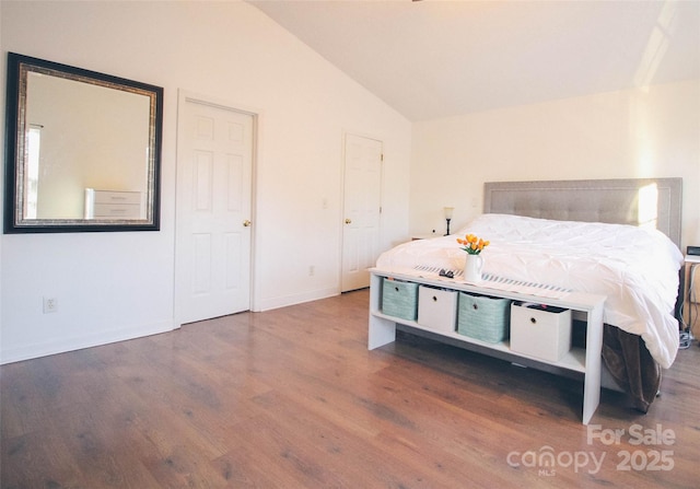 bedroom featuring dark wood-type flooring and lofted ceiling