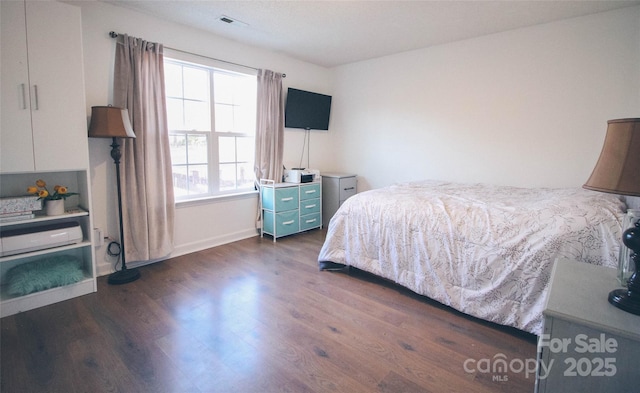 bedroom featuring dark wood-type flooring and multiple windows