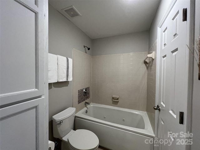 bathroom with toilet and tiled shower / bath combo