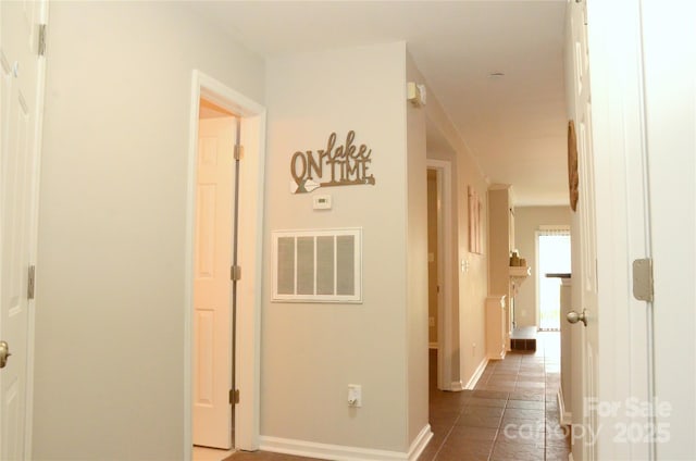 hall featuring dark tile patterned floors