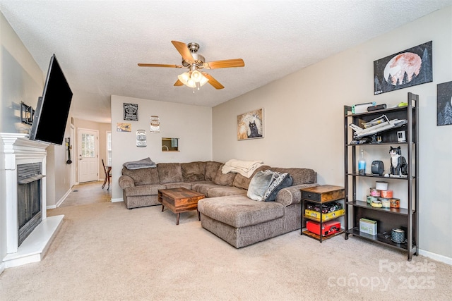 living room featuring ceiling fan, carpet flooring, and a textured ceiling