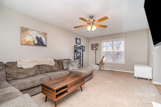 carpeted living room featuring ceiling fan and a textured ceiling