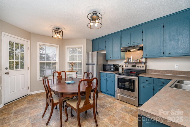 kitchen featuring blue cabinets, appliances with stainless steel finishes, sink, and a textured ceiling