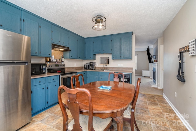 kitchen with blue cabinets, sink, a textured ceiling, and appliances with stainless steel finishes