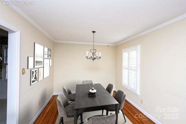 dining room with crown molding, hardwood / wood-style floors, and a notable chandelier