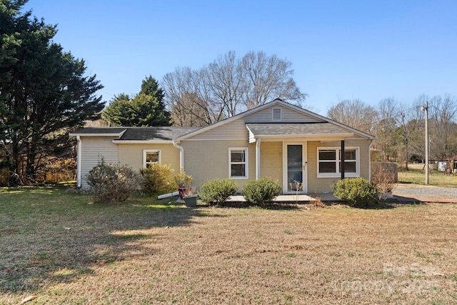 view of front of home featuring a shingled roof, a front yard, and covered porch