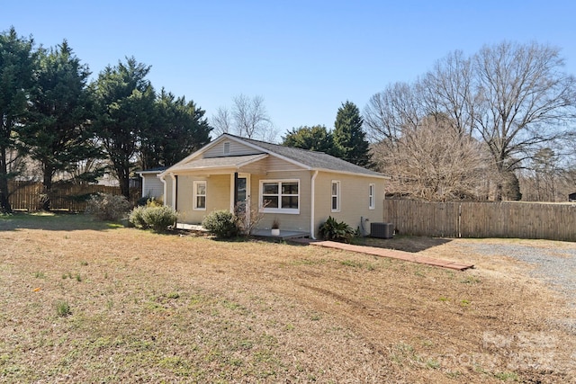 view of front of home featuring fence, cooling unit, and a front yard