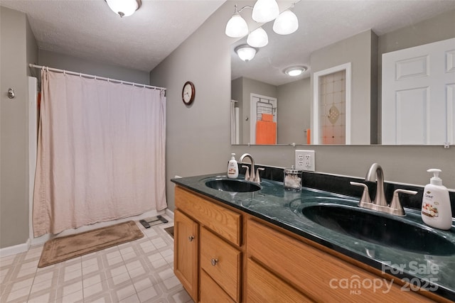 bathroom featuring curtained shower, a textured ceiling, and vanity