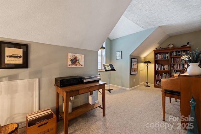 carpeted home office with a textured ceiling and lofted ceiling