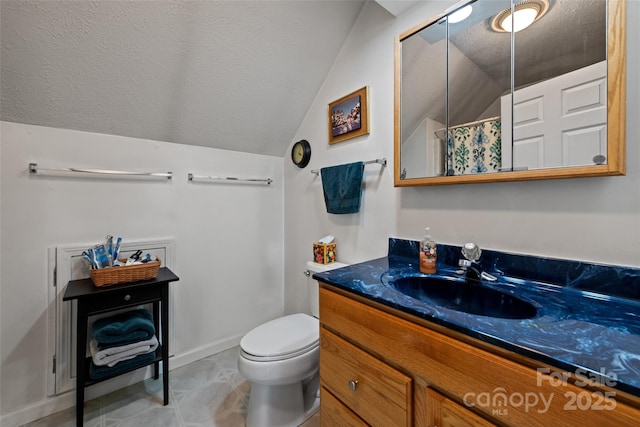 bathroom with a textured ceiling, toilet, vaulted ceiling, and vanity