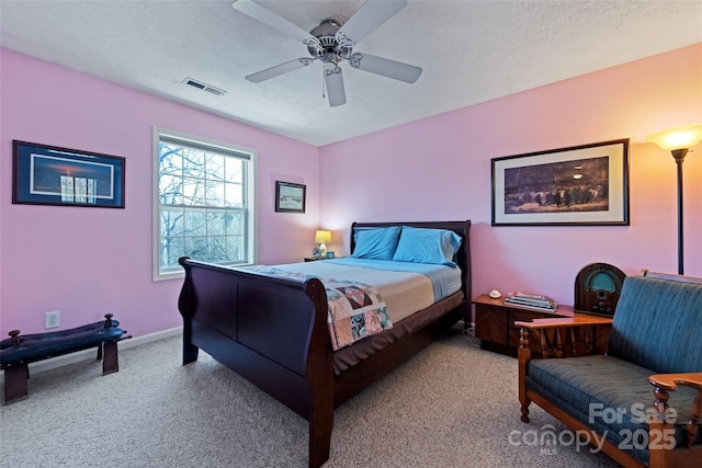 carpeted bedroom with ceiling fan and a textured ceiling