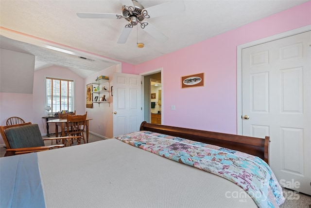 carpeted bedroom featuring ceiling fan, vaulted ceiling, and a textured ceiling