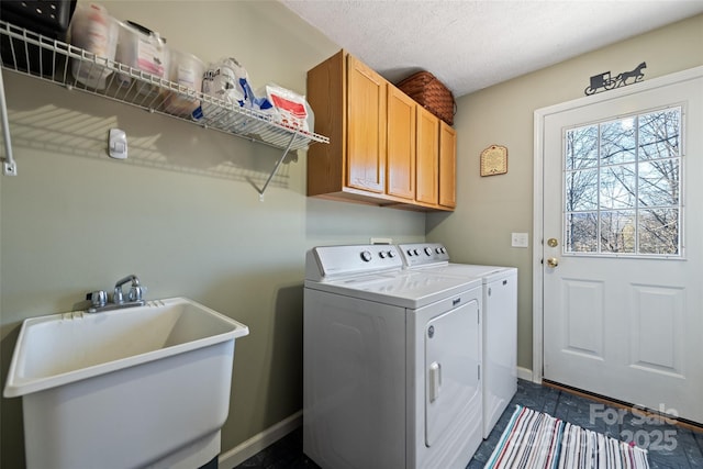 laundry room featuring cabinets, sink, a textured ceiling, and washing machine and dryer