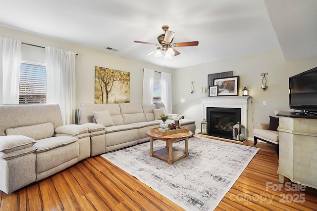 living room featuring hardwood / wood-style floors and ceiling fan