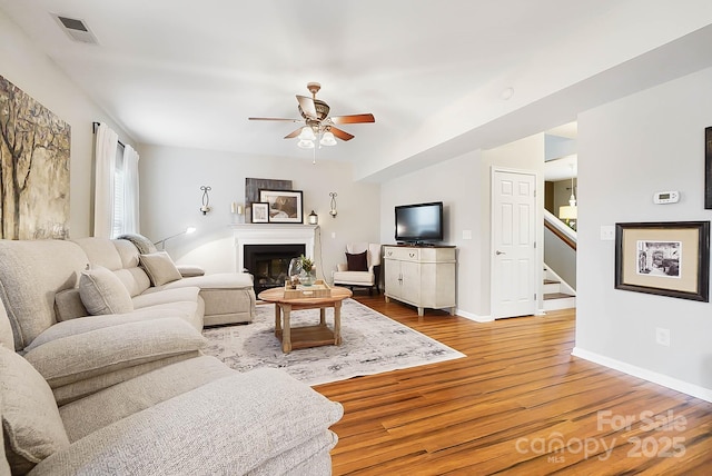 living room with ceiling fan and wood-type flooring