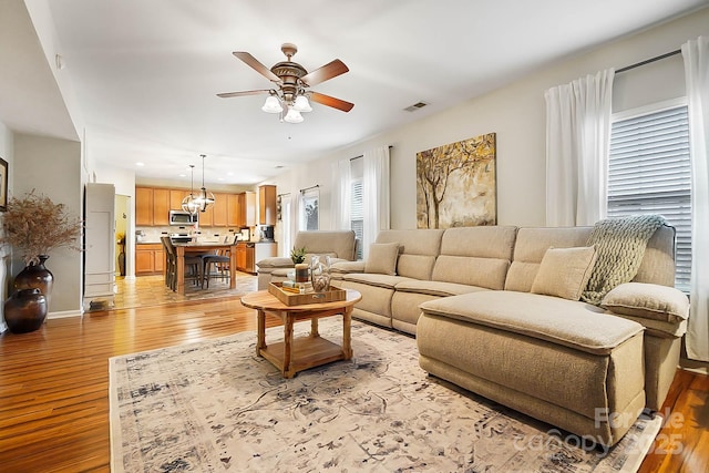 living room with ceiling fan and light wood-type flooring