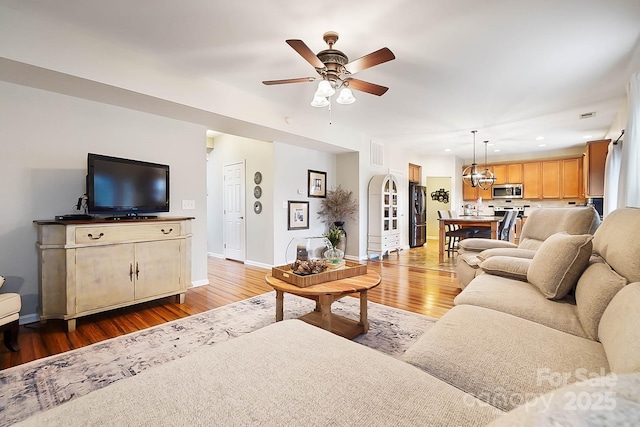 living room featuring ceiling fan and light hardwood / wood-style flooring