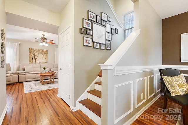 stairway featuring wood-type flooring and ceiling fan