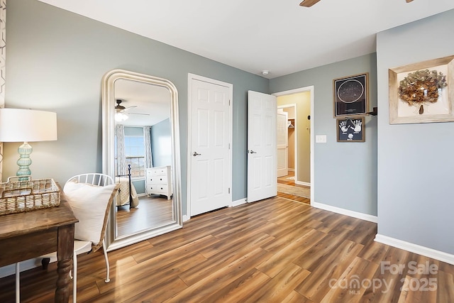 living area with dark wood-type flooring and ceiling fan