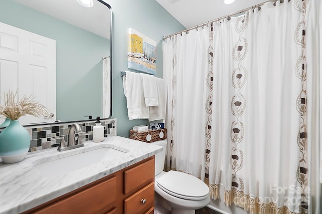 bathroom featuring vanity, toilet, and decorative backsplash