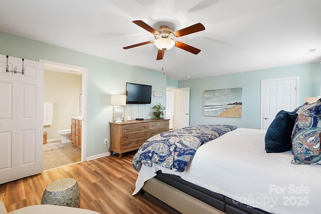 bedroom with connected bathroom, ceiling fan, and light hardwood / wood-style flooring