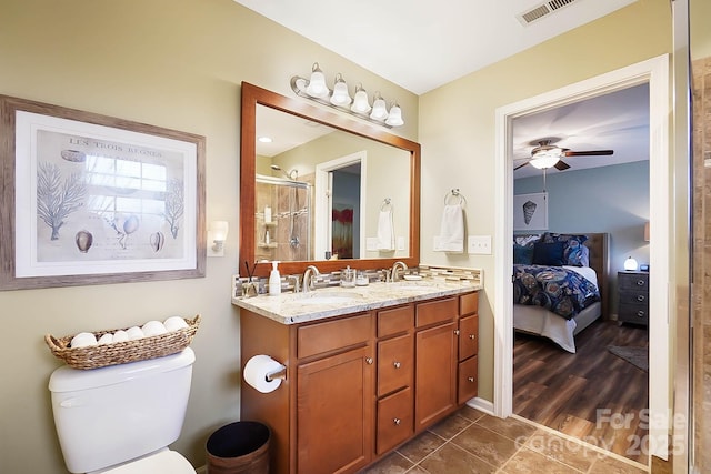 bathroom with vanity, walk in shower, ceiling fan, toilet, and tile patterned floors