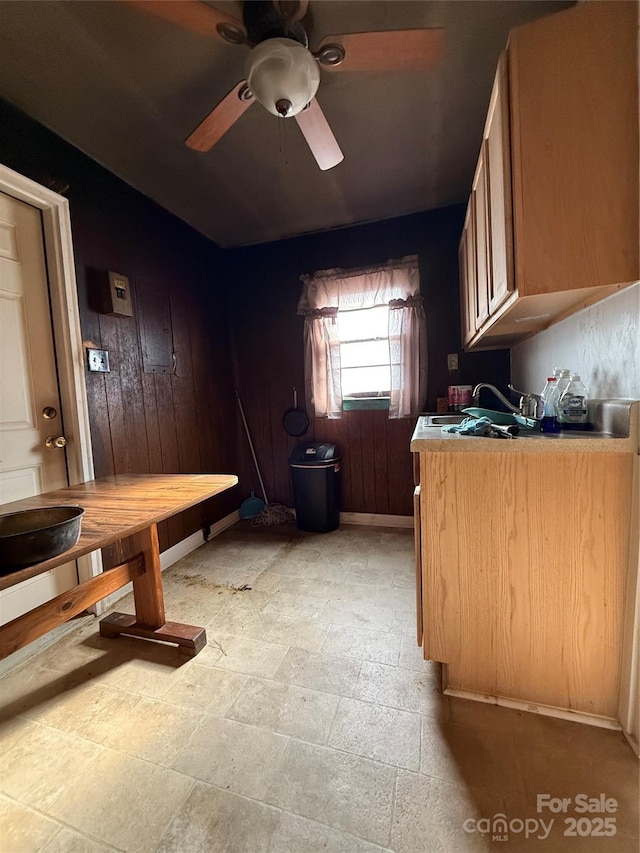 interior space with ceiling fan and wooden walls