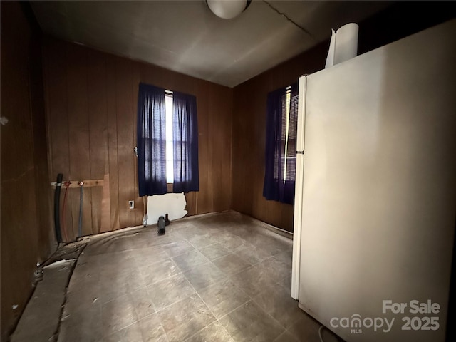 unfurnished room featuring wood walls