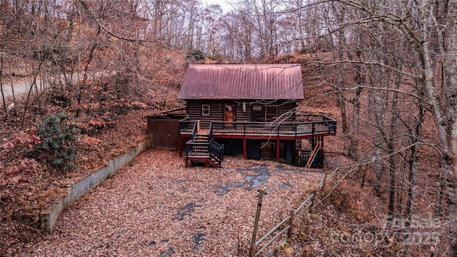 rear view of property featuring a wooden deck