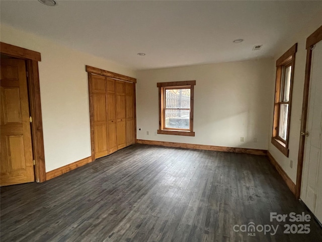 unfurnished bedroom featuring a closet and dark hardwood / wood-style floors