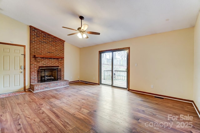 unfurnished living room with vaulted ceiling, ceiling fan, a fireplace, and light hardwood / wood-style floors