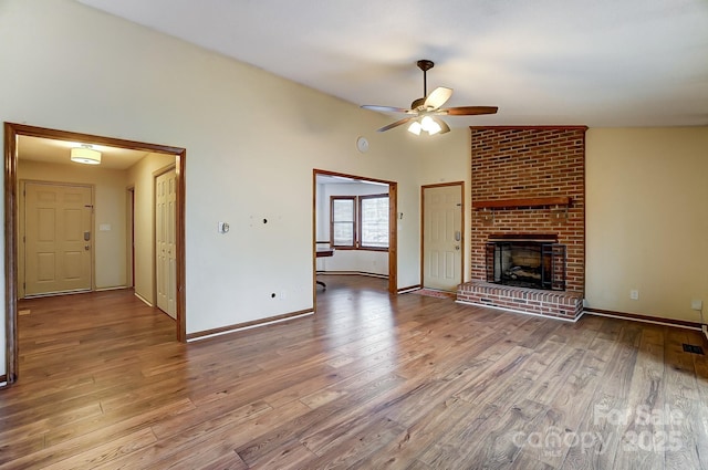 unfurnished living room with a fireplace, light hardwood / wood-style floors, and vaulted ceiling