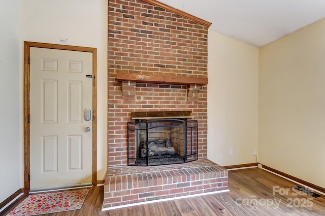 unfurnished living room with hardwood / wood-style flooring, a fireplace, and vaulted ceiling