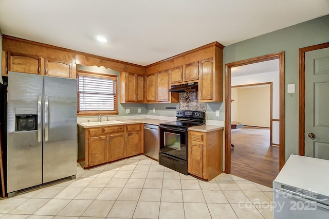 kitchen with stainless steel appliances, light tile patterned flooring, and sink