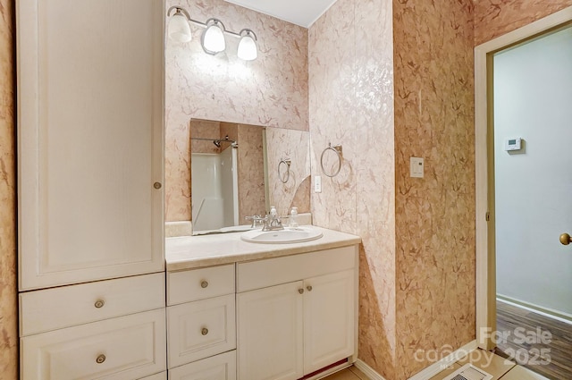 bathroom with walk in shower, vanity, and tile patterned flooring