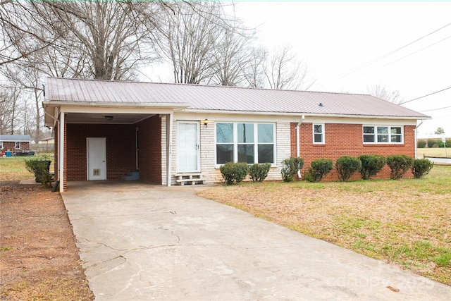 ranch-style house with brick siding, an attached carport, entry steps, concrete driveway, and metal roof