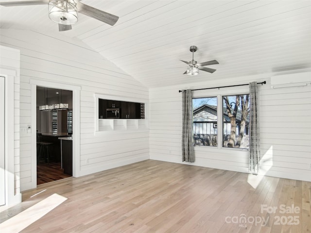 unfurnished room with hardwood / wood-style flooring, ceiling fan, vaulted ceiling, and a wall mounted air conditioner